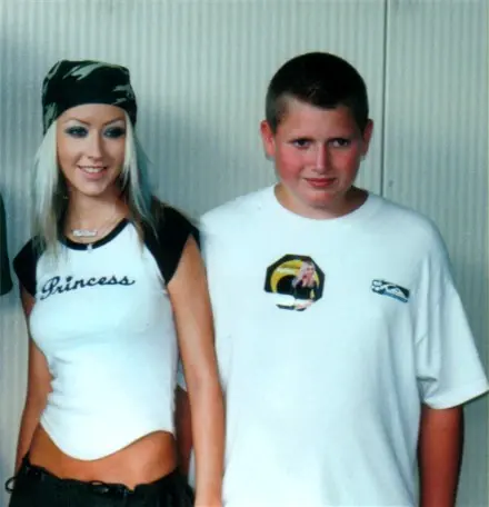 A young performer in a bandana standing with a teenage fan at a meet and greet
