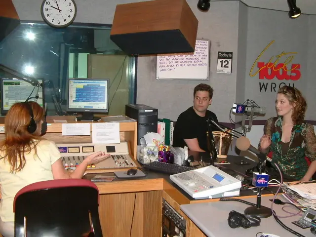Inside the WRCH on-air studio, an operator working the board while a second person sits at the microphone