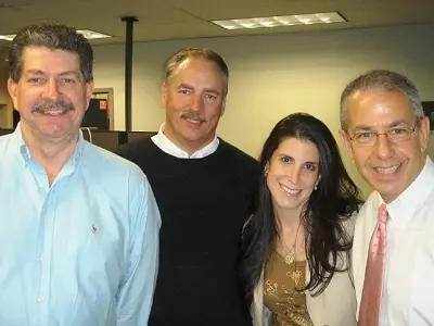 Three colleagues posed together in an office at the station