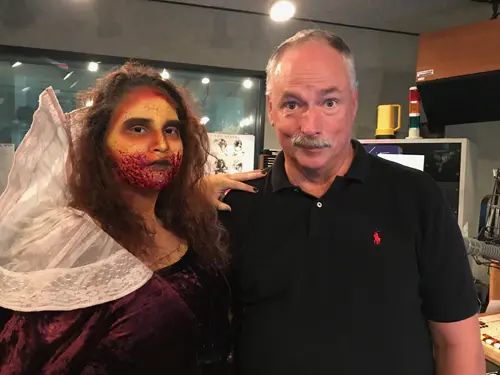 Allan Camp with a costumed visitor to the studio in elaborate face paint and a lace veil